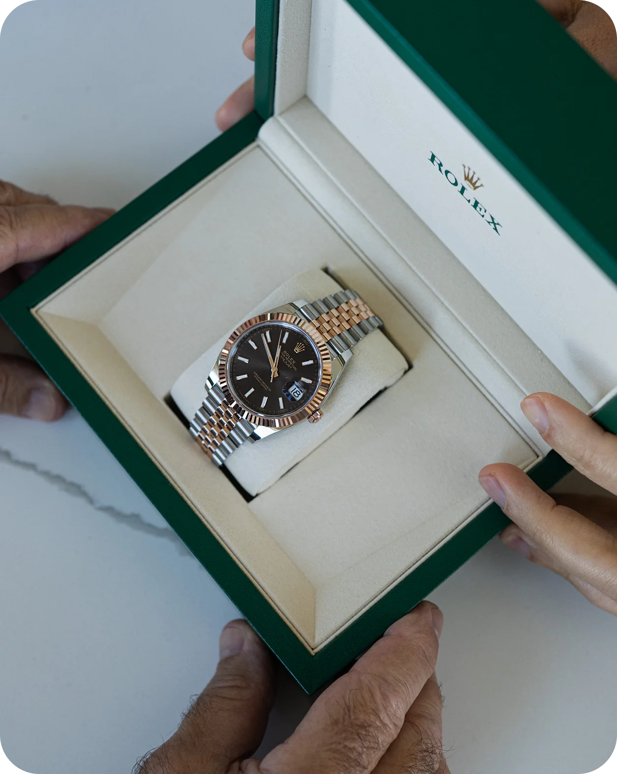 A two-tone Rolex in its green presentation box