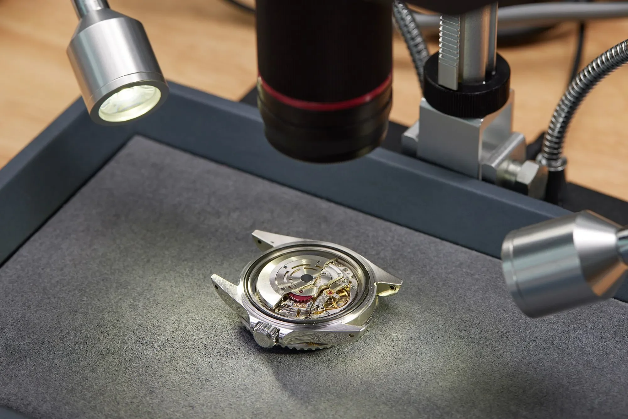 A watch movement under a magnifying lamp