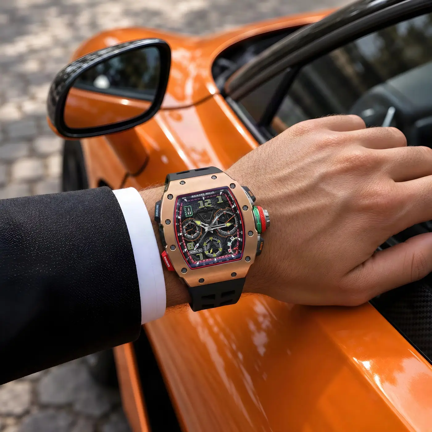 Richard Mille in rose gold on a wrist beside an orange car